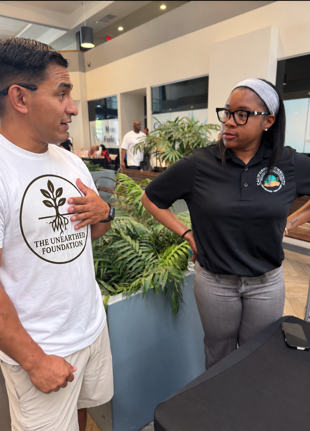 Vincent from The Unearthed Foundation speaking with a community partner at an employment and resource fair